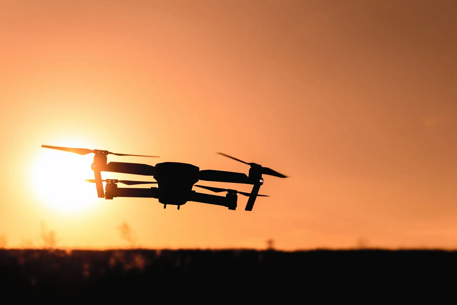 Drone silhouetted against the setting sun