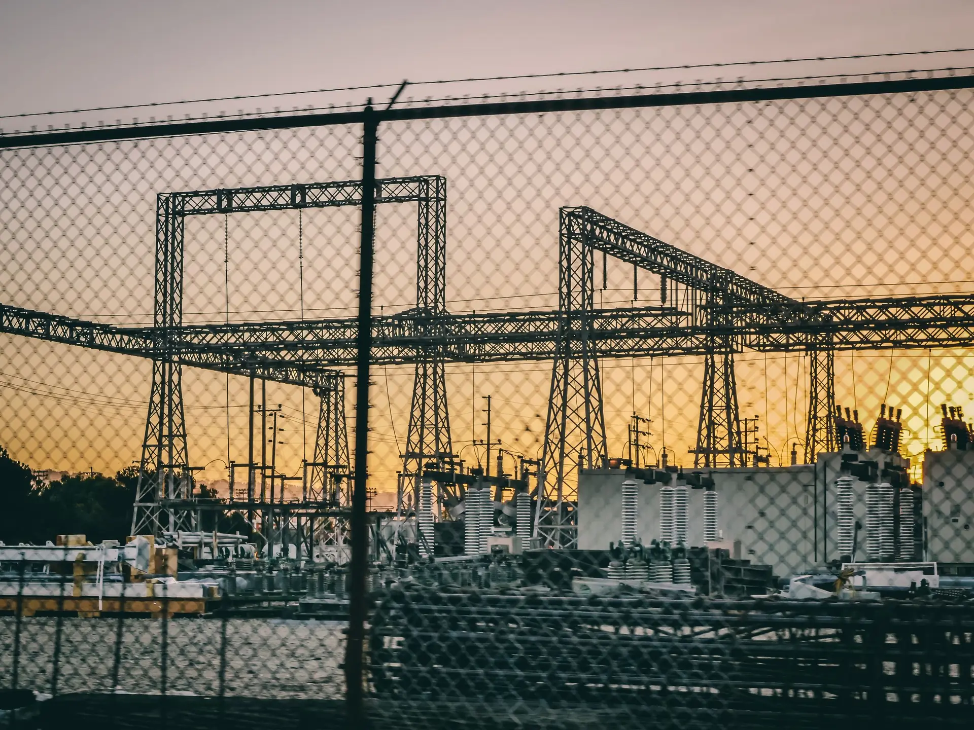 Power plant at dusk behind a security fence